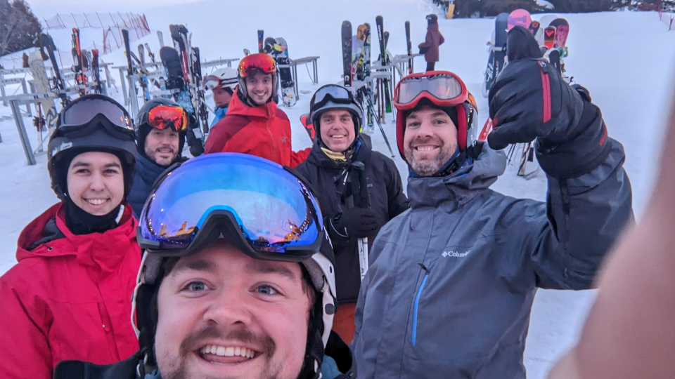 OKIOK colleagues in ski helmets and goggles at the foot of the slopes.