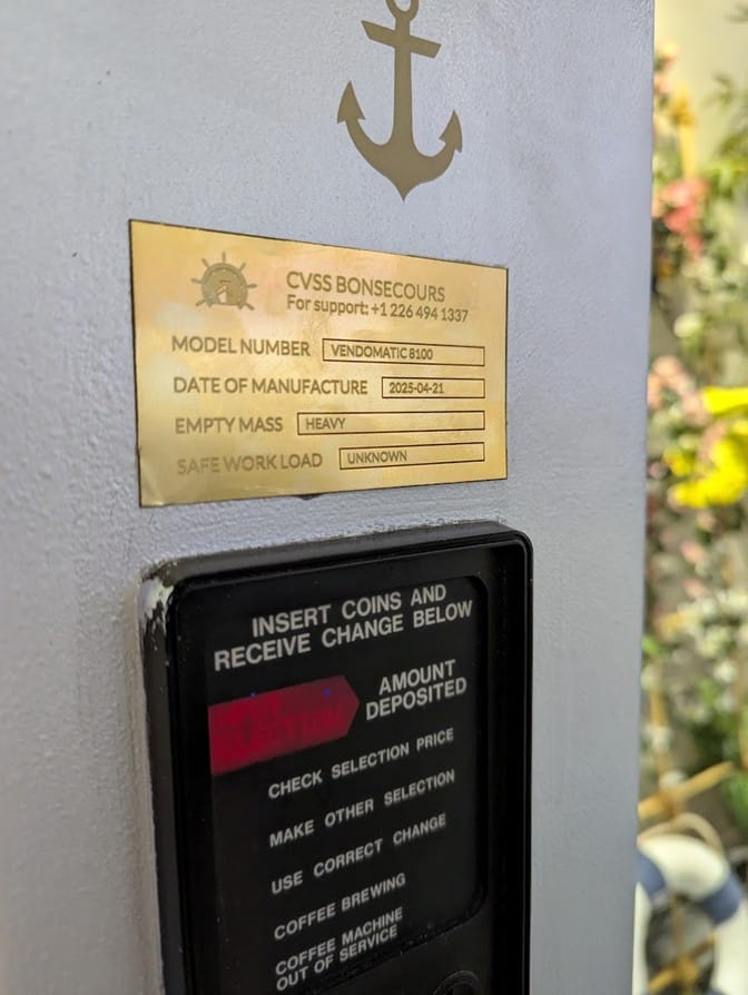 The vending machine’s metal info panel, carrying a support number that contains 1337.